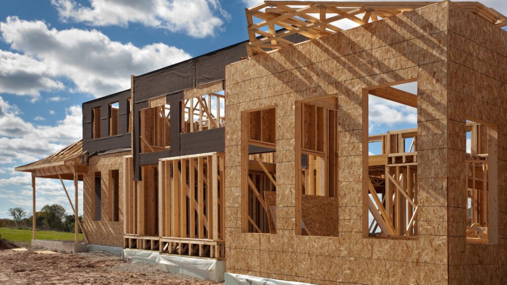 A new home construction in the middle of being built during a sunny day.
